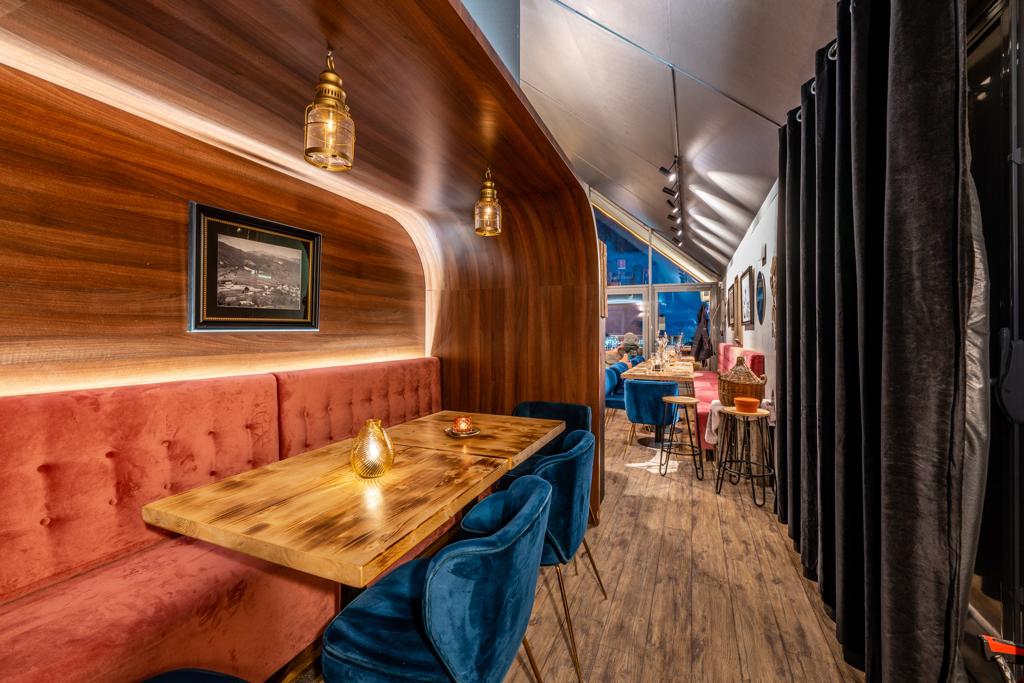 Vue intérieure de la salle de notre restaurant à Serre Chevalier, présentant un décor moderne et chaleureux avec un éclairage tamisé et un ameublement élégant
